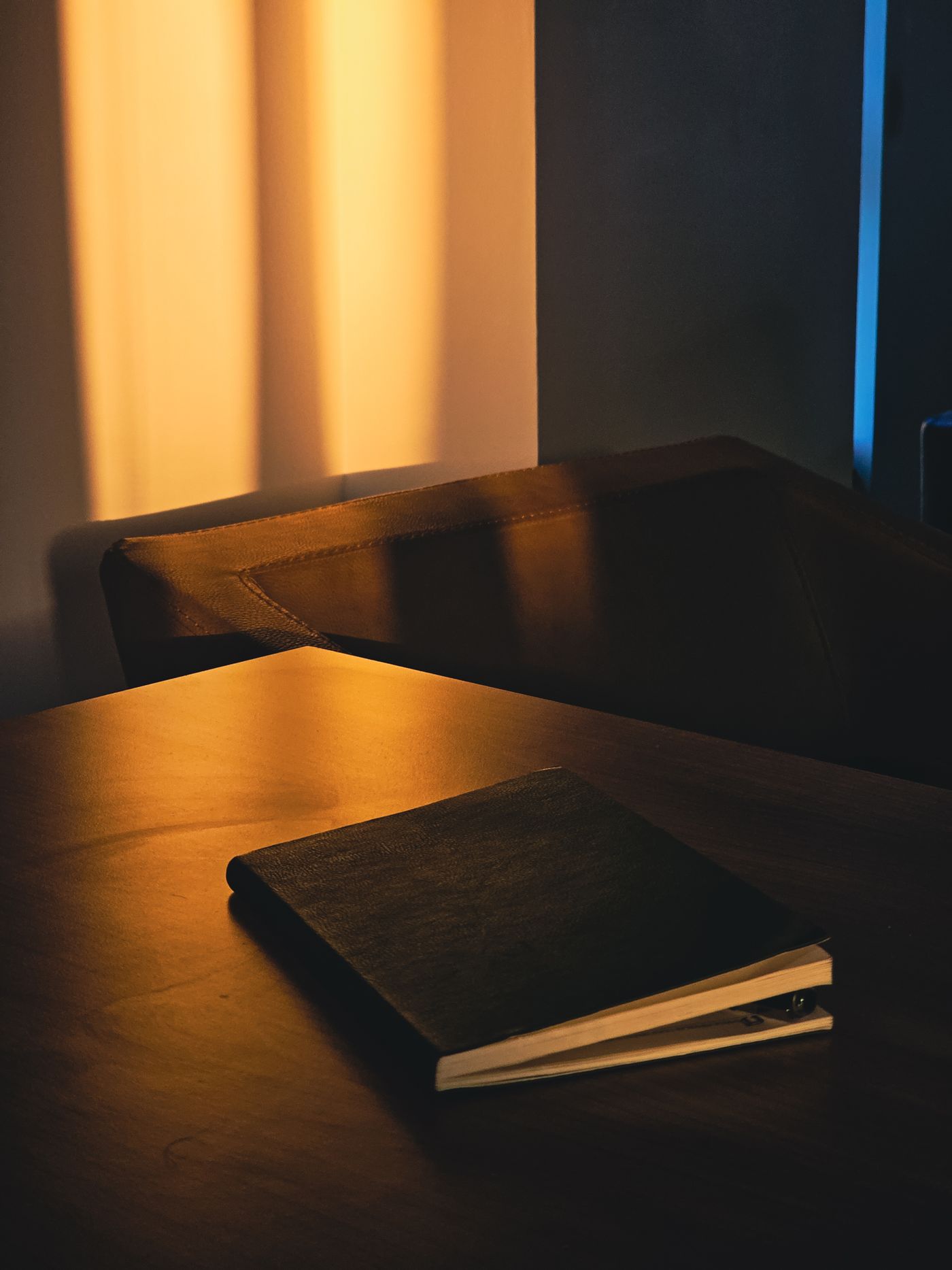 A closed notebook on a desk in evening light
