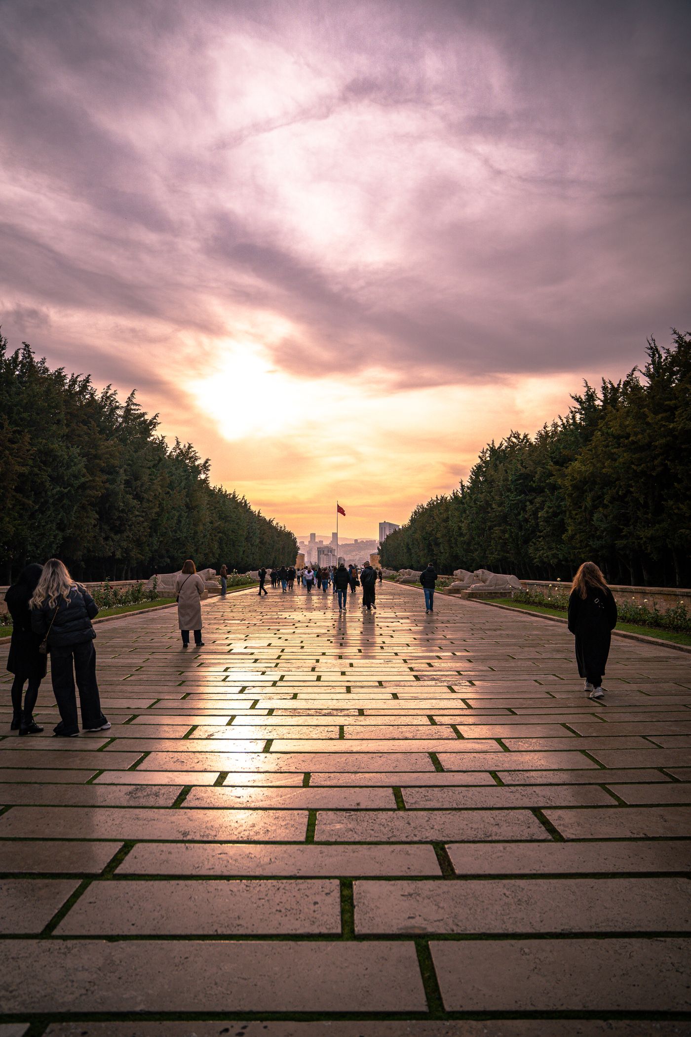People walking along a path at sunset