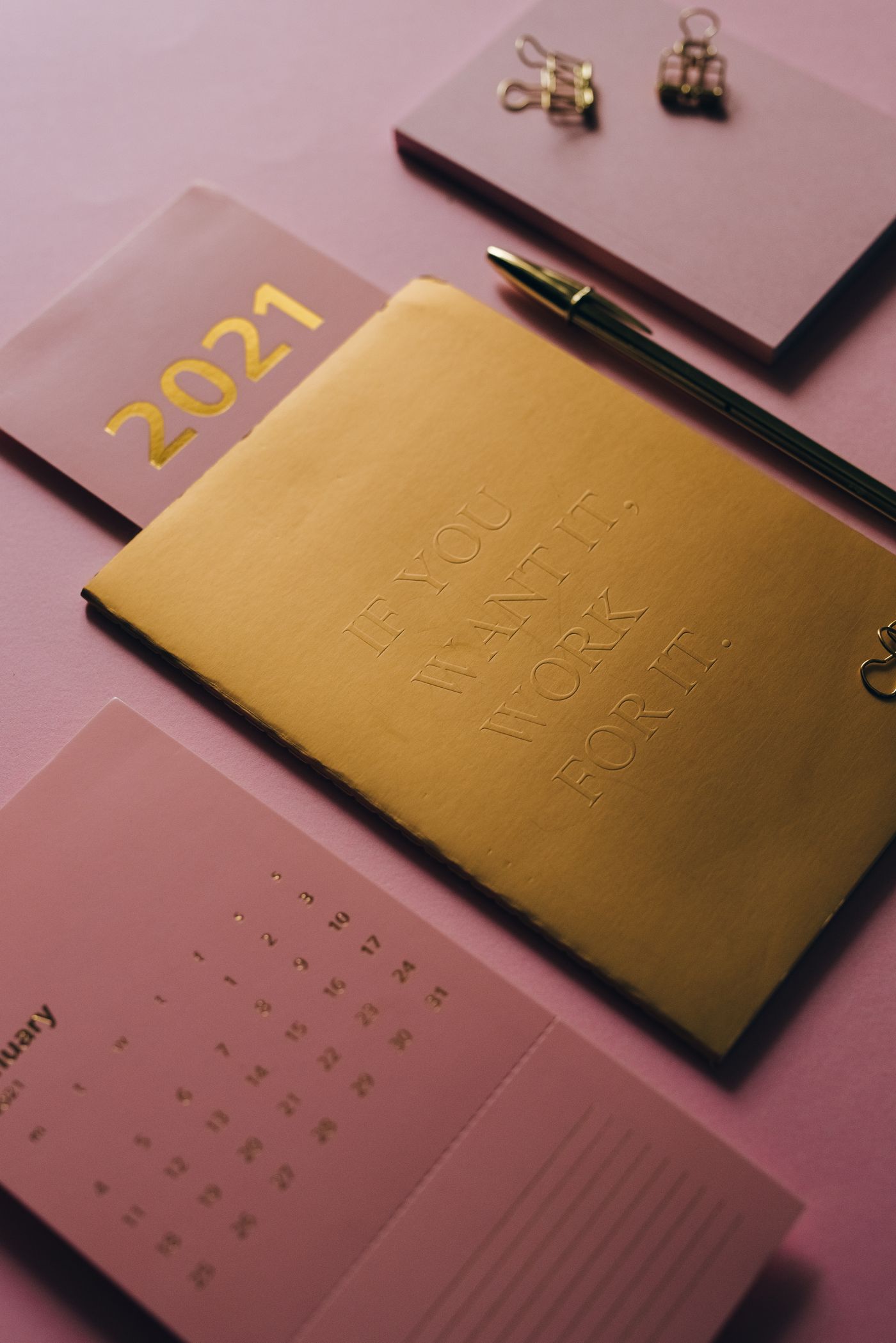 Notebook and calendar on a pink background